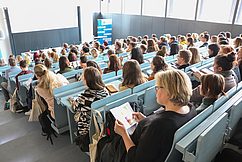 Ein Bild aus dem größten Hörsaal der Fakultät. Studierende sitzen und verfolgen die Veranstaltung